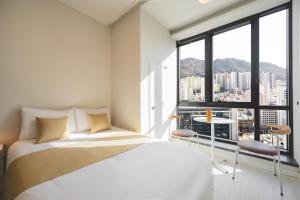 a bedroom with a bed and a large window at Gem Stay Seomyeon in Busan