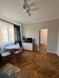 a living room with a table and chairs and a table at Apartament Mazurski Azyl in Szczytno