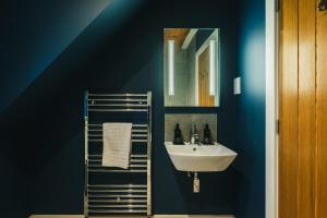a blue bathroom with a sink and a mirror at The Lookout in Ilkley +21 photos
