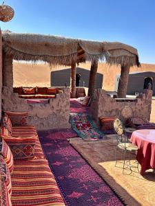 a room with tables and chairs in the desert at Chigaga Luxury Camp in Mhamid