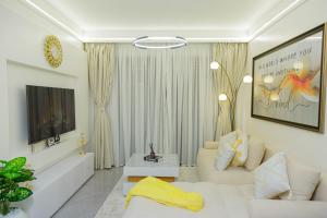 a living room with a couch and a tv at Riara One Residency in Gatunga