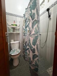 a bathroom with a toilet and a shower curtain at Rahayu House in Kusamba