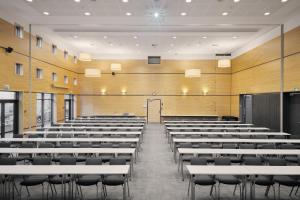 an empty lecture hall with white tables and chairs at Hotel Svendborg in Svendborg