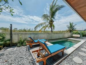 a patio with two chairs and a swimming pool at Kerti Suite in Munggu