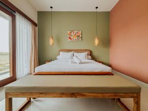 a bedroom with a large bed and two pendant lights at Kerti Suite in Munggu +37 photos