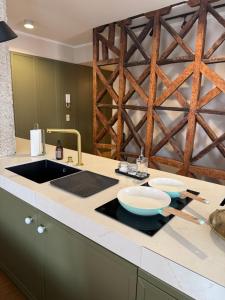 a kitchen with a sink and a wooden wall at Casa das Tertúlias in Leiria