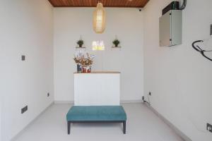 a white room with a bench and a stool at Kerti Suite in Munggu