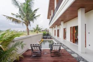 a patio with chairs and a pool in a house at Kerti Suite in Munggu