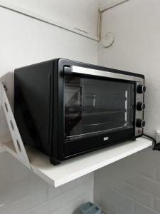 a microwave sitting on a shelf in a kitchen at Relax en el Centro, Moderno Depto con AC y Estilo in Posadas