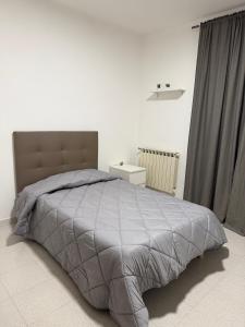 a bedroom with a large bed with a gray comforter at B&B Boffa in Buccino +3 photos