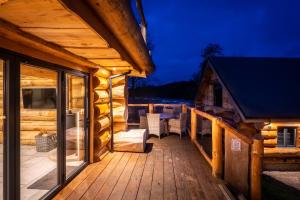 a deck of a log cabin at night at Keepers Cabin in Ilkley