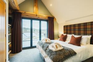 a bedroom with a bed with a large window at Keepers Cabin in Ilkley