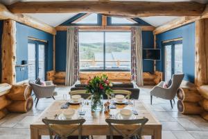 a living room with a table and chairs and a large window at The Farmhouse in Ilkley