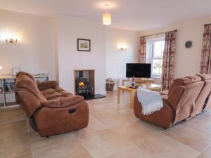 a living room with two couches and a fireplace at Finn Cottage in Strabane