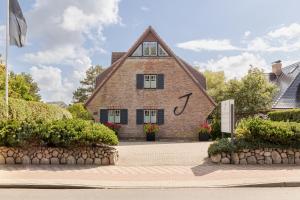 a house with a clock on the side of it at Jaumann's Südwind Sylt in Westerland