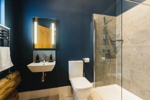 a bathroom with a toilet and a shower and a sink at The Farmhouse in Ilkley