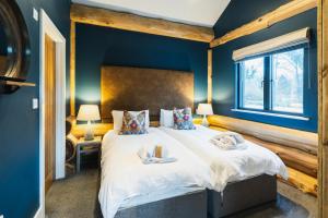 a bedroom with a large bed with blue walls at The Farmhouse in Ilkley