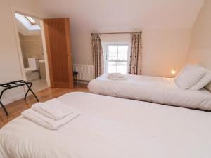two beds in a room with a window at Finn Cottage in Strabane