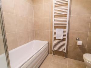 a bathroom with a bath tub and a toilet at Finn Cottage in Strabane +12 photos