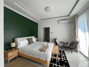 a bedroom with a bed and a green wall at Casa-Pel Villa Grande in Palatswe