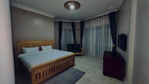 a bedroom with a bed and a television in it at Kuri hotel Kampala in Kampala