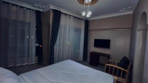a bedroom with a bed and a desk and a television at Kuri hotel Kampala in Kampala