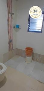 a bathroom with a toilet and a window at Hotel Shiv Sai in Shirdi +16 photos