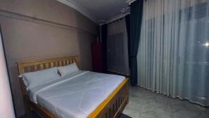 a bedroom with a large bed with a window at Kuri hotel Kampala in Kampala +2 photos