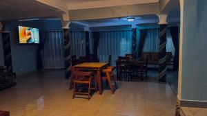 a dining room with a wooden table and chairs at Kuri hotel Kampala in Kampala