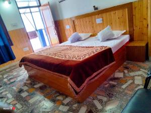 a bedroom with a large wooden bed in a room at Hotel Kailash View, Kalpa in Kalpa