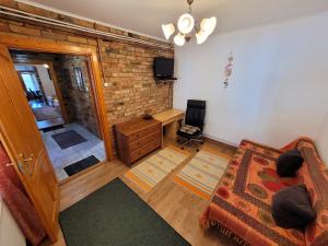 a living room with a couch and a brick wall at Mandula Apartman in Szeged