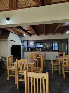 a dining room with wooden tables and chairs at Bosque Hostel in Villa Traful