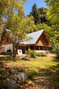 a log cabin with a sign in front of it at Bosque Hostel in Villa Traful