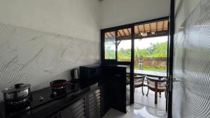 a kitchen with a counter with a stove and a window at Shima Tunjung in Darmasaba