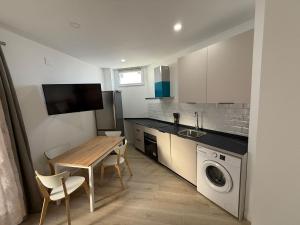 a small kitchen with a table and a washing machine at Independent Apartment At Villa Noelia Benalmádena With Private Pool, Garden & Parking in Benalmádena