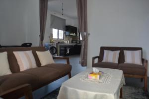 a living room with two couches and a table at Airways Residence in Plaine Magnien
