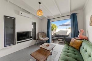 a living room with a green couch and a table at Saint Joris a tiny Boutique Resort in Willemstad