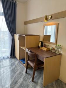 a desk with a mirror and a chair in a room at Spring II Hotel in Ấp Bình Hòa (1)