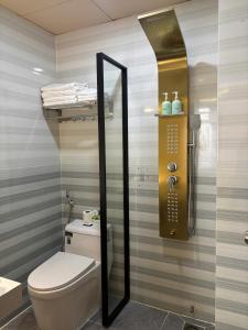 a bathroom with a toilet and a shower with a mirror at Spring II Hotel in Ấp Bình Hòa (1)