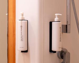 two white and black shampoo bottles on a wall at Martini Hotel in Groningen