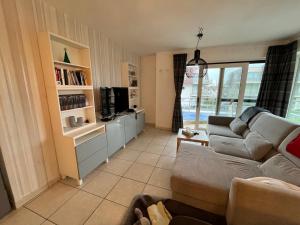 a living room with a couch and a microwave at Blutsyde Cannes luxury appartment in Bredene