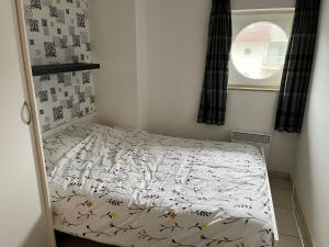 a small bedroom with a bed and a window at Blutsyde Cannes luxury appartment in Bredene +1 photo