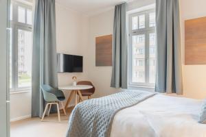 a bedroom with a bed and a table and windows at Key Inn serviced residences Belair in Luxembourg