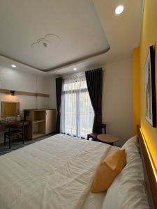 a bedroom with a large bed and a desk at Spring II Hotel in Ấp Bình Hòa (1)