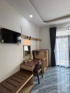 a room with a desk and a table and a television at Spring II Hotel in Ấp Bình Hòa (1)