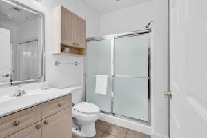 a bathroom with a shower and a toilet and a sink at Myrtlewood by Monarch Rentals in Myrtle Beach +12 photos