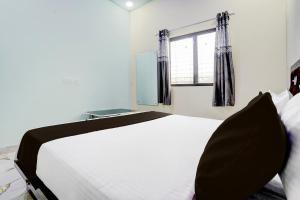 a bedroom with a large white bed and a window at SPOT O SKY LINE in Chandrapur +19 photos