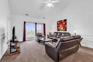 a living room with a couch and a tv at Myrtlewood by Monarch Rentals in Myrtle Beach