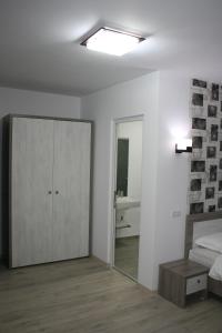 a bedroom with a bed and a mirrored cabinet at Riana in Adjud