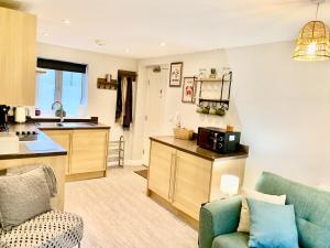 a living room with a couch and a kitchen at The Coach House, Cleobury Mortimer in Cleobury Mortimer